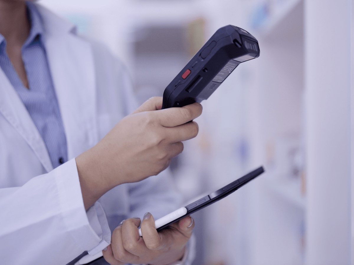 A pharmacist scanning a prescription item in the RxNow Pharmacy dispensary